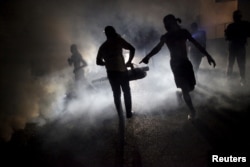 FILE - A worker of the Ministry of Public Health and Population fumigates in the street against mosquito breeding to prevent diseases such as malaria, dengue and Zika in Port-au-Prince, Haiti, Feb. 15, 2016.
