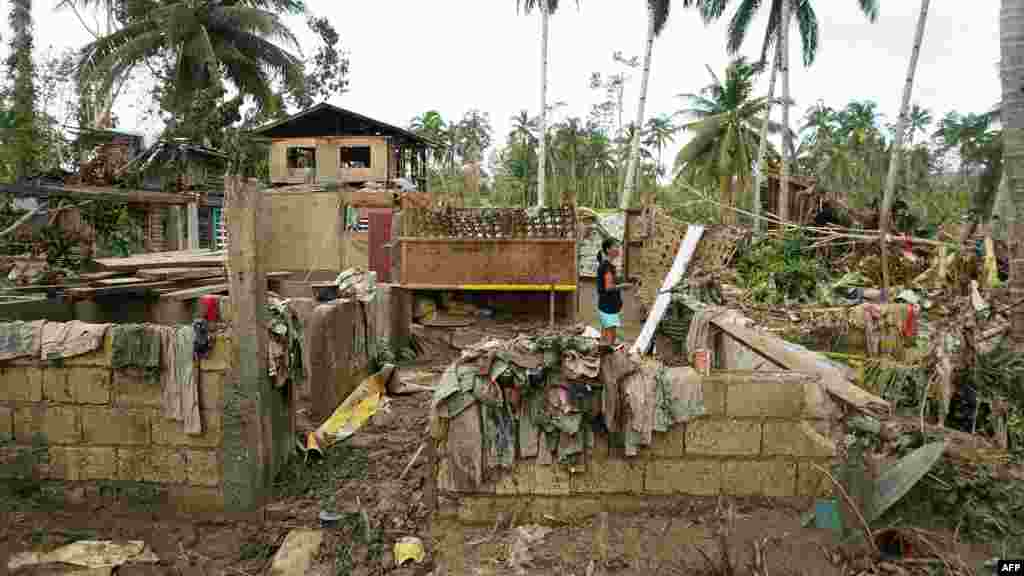 A resident stands inside a destroyed house in Loboc town, Bohol province, Philippines, days after super Typhoon Rai devastated the province.