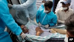 Los trabajadores de la salud llevan a un paciente después de un incendio en el hospital Vijay Vallabh en Virar, cerca de Mumbai, India, el 23 de abril de 2021.