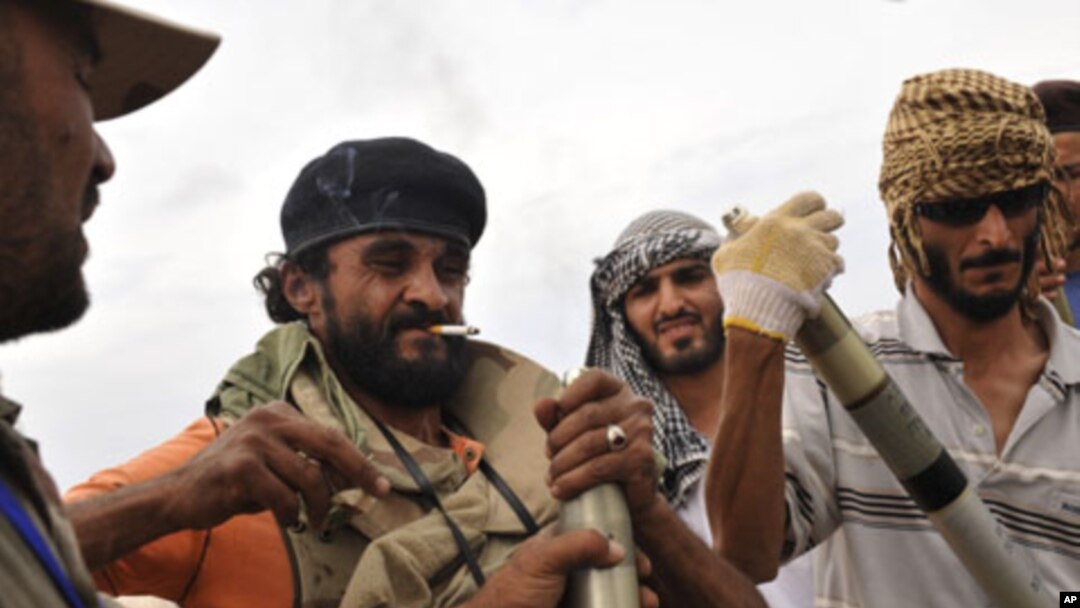 Libyan revolutionary fighters assemble missiles during an attack for the city of Sirte, Libya, October 3, 2011.