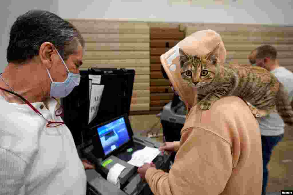 Barton Foley, 32, with his cat "Little Ti Ti" on his shoulder, casts his ballot on Election Day at Ballard High School in Louisville, Kentucky, Nov. 3, 2020.