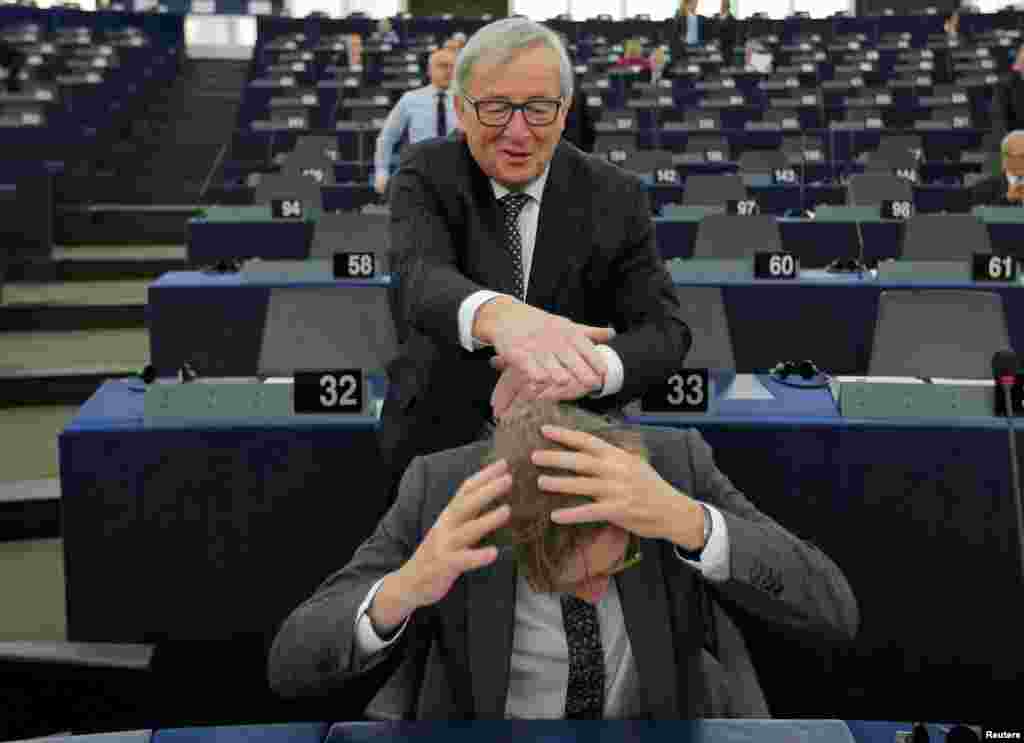European Commission President Jean-Claude Juncker jokes with European Union's chief Brexit negotiator Guy Verhofstadt ahead of a debate on the Future of Europe at the European Parliament in Strasbourg, France.