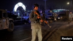 FILE - An Afghan police officer keeps watch at the site of a suicide bomb attack in Kabul, Nov. 20, 2018. 