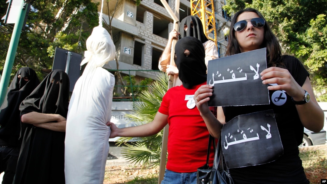 FILE - In this Thursday, April 1, 2010 file photo, activists from a civil organization reenact an execution scene in front of the Saudi Arabia Embassy in Beirut, Lebanon, as they protest a possible beheading of a Lebanese man accused of witchcraft in Saudi Arabia.