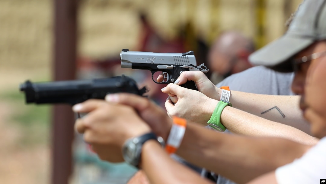 FILE - Shooters practice with pistols at a gun range near Colorado Springs, Colo.