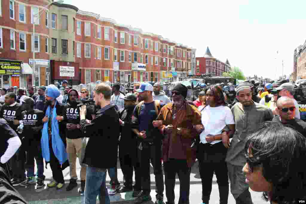 Baltimore police responded briefly with pepper spray before civilians linked arms to form two parallel chains between disquieted demonstrators and the police, Apr 28, 2015 (VOA photo/ Victoria Macchi).