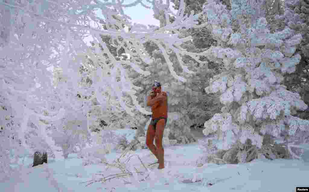 A member of the Cryophile amateur winter swimmers' club rubs himself with snow after bathing in the icy waters of the Yenisei River during below freezing temperatures in Krasnoyarsk, Russia, Feb. 2, 2019.