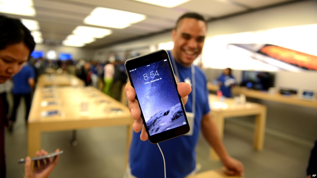 Un representante de Apple muestra un iPhone 6 en una tienda de Canadá.