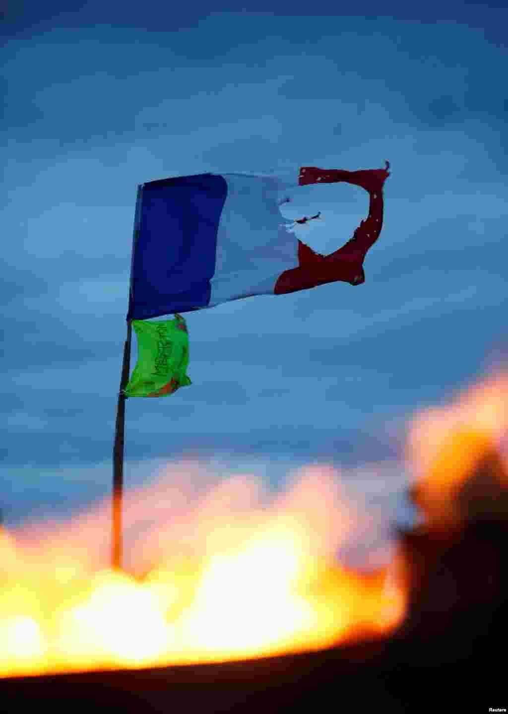 A French flag and a yellow vest are seen at a roundabout occupied by 'yellow vests' protesters in Roppenheim, France.