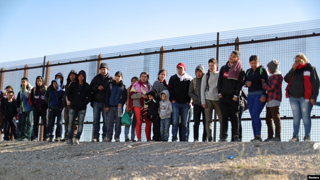 FILE - A group of Central American migrants surrenders to U.S. Border Patrol Agents south of the U.S.-Mexico border fence in El Paso, Texas, March 6, 2019.