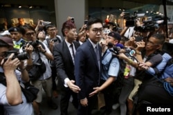 FILE - Andy Chan is surrounded by photographers as he leaves the Foreign Correspondents' Club in Hong Kong, Aug. 14, 2018.