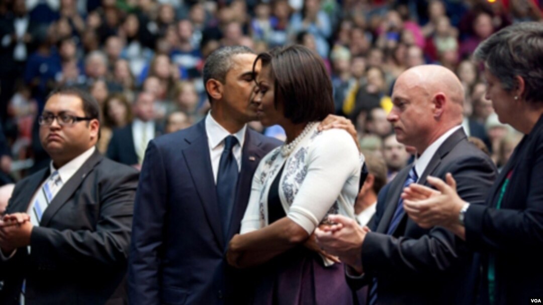 A la izquierda, Daniel Hernández aplaude, mientras el presidente Obama abraza a la primera dama Michelle Obama, con el esposo de Giffords, Mark Kelly y la secretaria Janet Napolitano a la dderecha en la foto.
