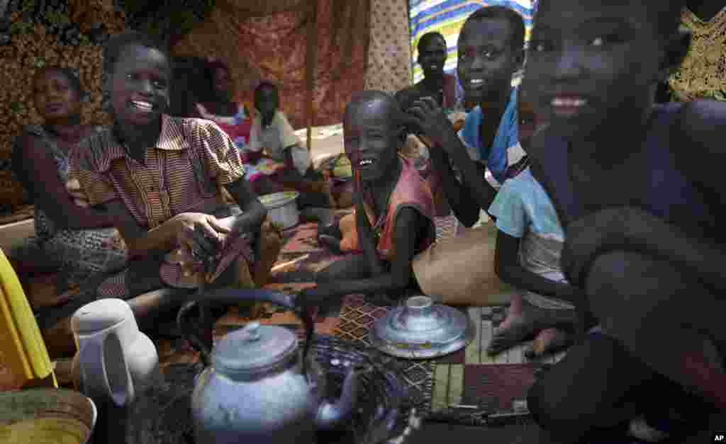 Uma família faz chá fora do seu abrigo improvisado no campo de refugiados das Nações Unidas, nova casa de milhares de deslocados de guerra por causa do conflito que eclodiu em Jebel, arredores da capital Juba, no Sudão do Sul. Dez. 31, 2013.