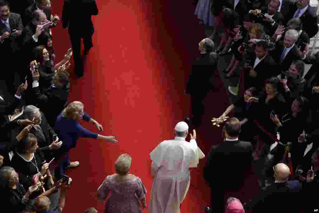 Flanked by Panama's President Juan Carlos Varela, right, and first lady Lorena Castillo, Pope Francis arrives at the foreign ministry headquarters Palacio Bolivar, in Panama City.