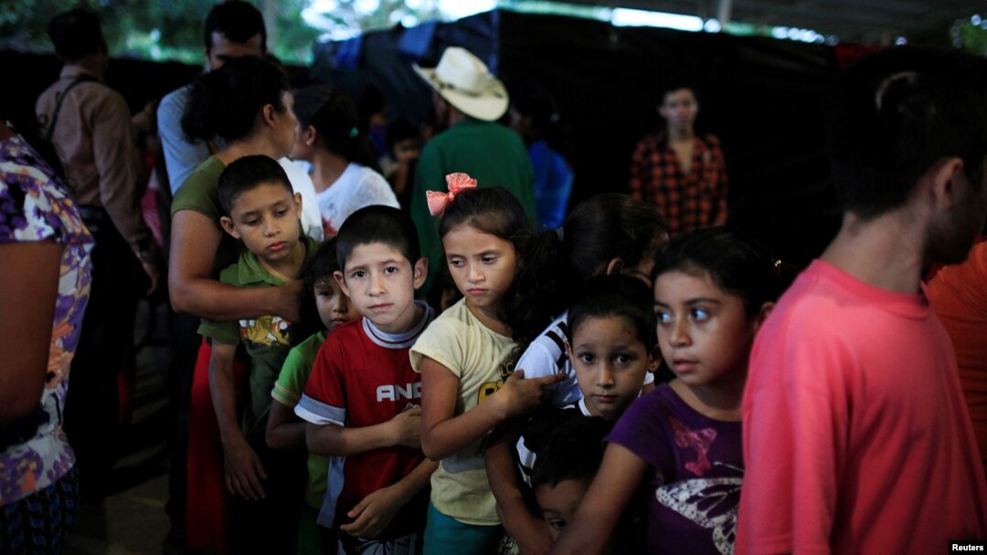  Children line up at dinner time at a shelter for displaced people from El Castano village in the town of Caluco, El Salvador, Sept. 26, 2016. 