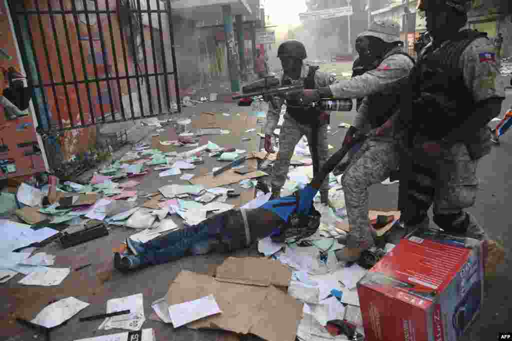 A man who was caught looting in a shop is arrested by police in the center of Haitian capital Port-au-Prince, Feb. 12, 2019, as a sixth day of protests continued against Haitian President Jovenel Moise and the misuse of Petrocaribe funds.