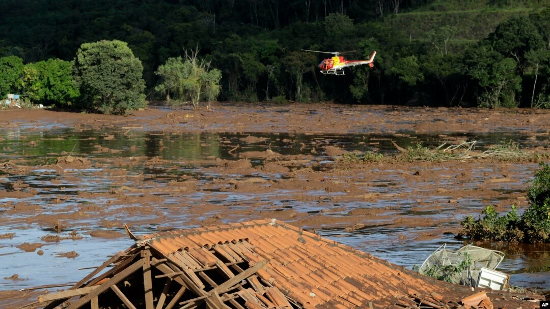 Rescue workers in a helicopter search a flooded area after a dam collapsed in Brumadinho, Brazil, Jan. 27, 2019. 