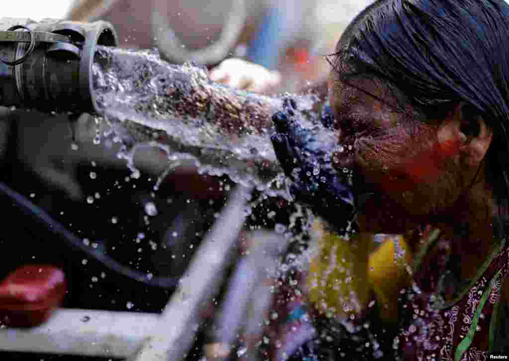 An indigenous woman from the Kayapo tribe washes her face near a water tanker at the Terra Livre camp, or Free Land camp, during a protest to defend indigenous land and cultural rights the demonstrators say are threatened by the right-wing government of Brazilian President Jair Bolsonaro, in Brasilia, April 24, 2019.