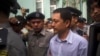 FILE - Kyaw Min Swe, center, is escorted by police upon arrival at the township court in Yangon, Myanmar, June 16, 2017. The journalist was arrested at his home in Yangon on April 11, 2023, after posting a black square on Facebook, in an apparent comment related to an airstrike.