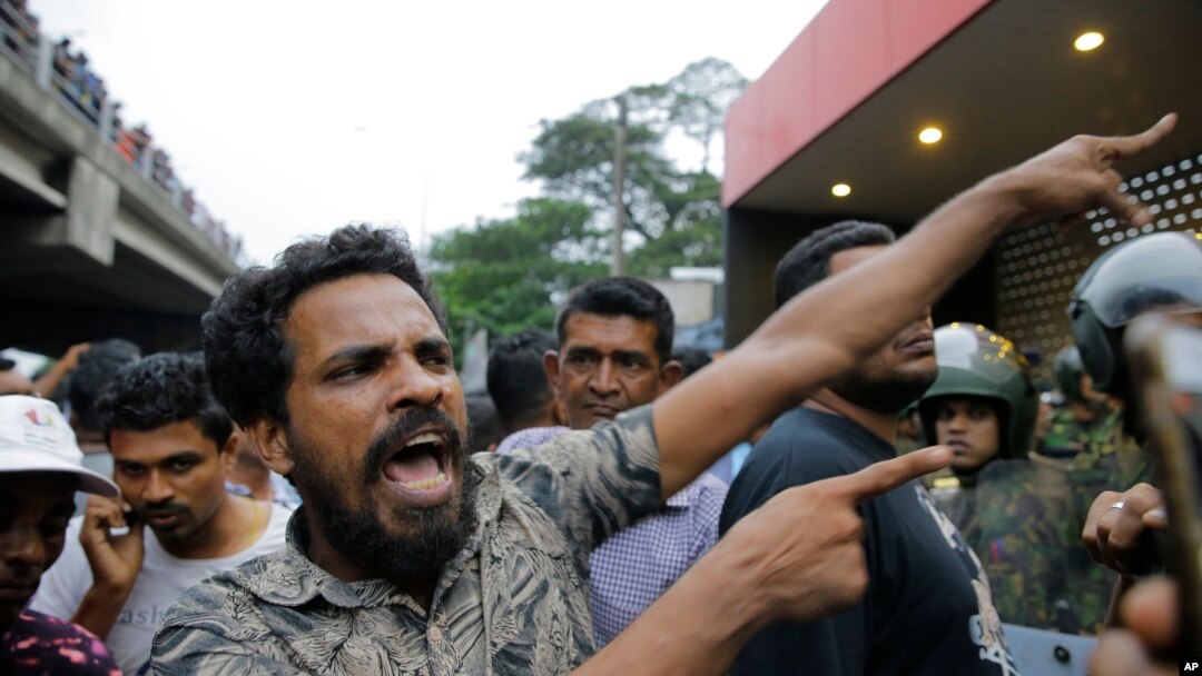 A supporter of newly appointed Sri Lankan prime minister Mahinda Rajapaksa shouts at police officers outside the Petroleum Ministry building in Colombo, Sri Lanka, Oct. 28, 2018.