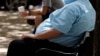 FILE - An overweight man rests on a bench in Jackson, Miss.