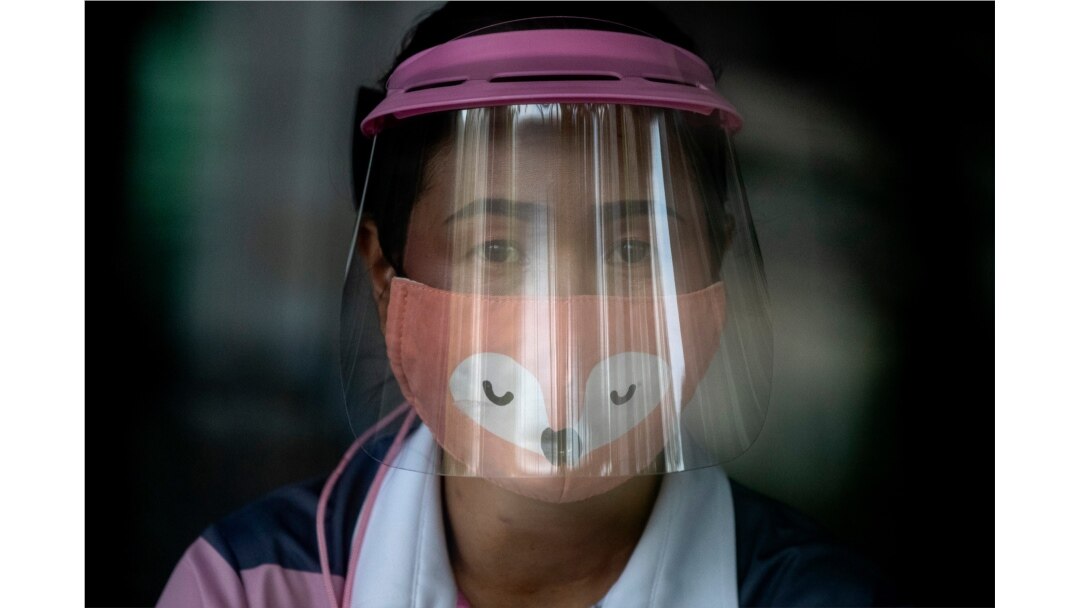 A volunteer wearing a face shield and mask manages a counter of COVID-19 infection screening center at the Chulalongkorn University health service center in Bangkok, Thailand, April 1, 2020.