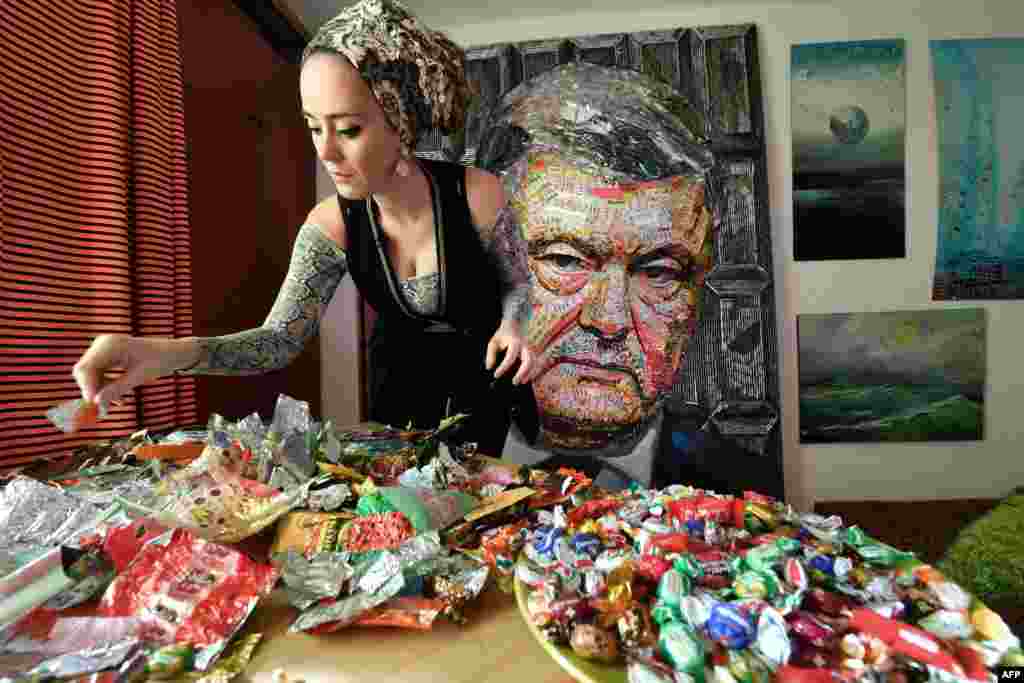 Ukrainian artist Daria Marchenko creates a large-scale artwork entitled 'The Face of Corruption' depicting President Petro Poroshenko, made with sweet wrappers of Roshen, the Poroshenko's confectionery company, in her workshop in Kiyev, March 28, 2019, ahead of the March 31 presidential elections.