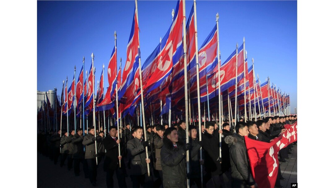 FILE - North Koreans parade with the North Korean flag in Kim Il Sung Square in Pyongyang to show their loyalty to the Workers' Party, Feb. 25, 2016.