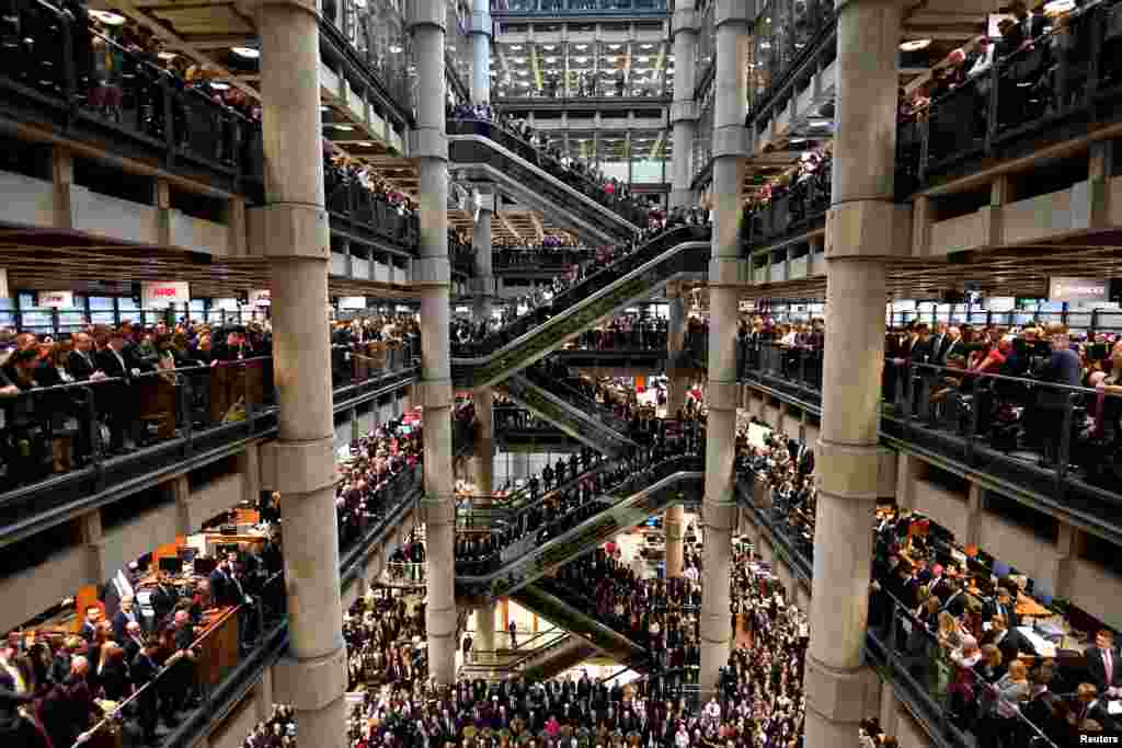 Workers stand during a Remembrance Service at the Lloyd's building in London.
