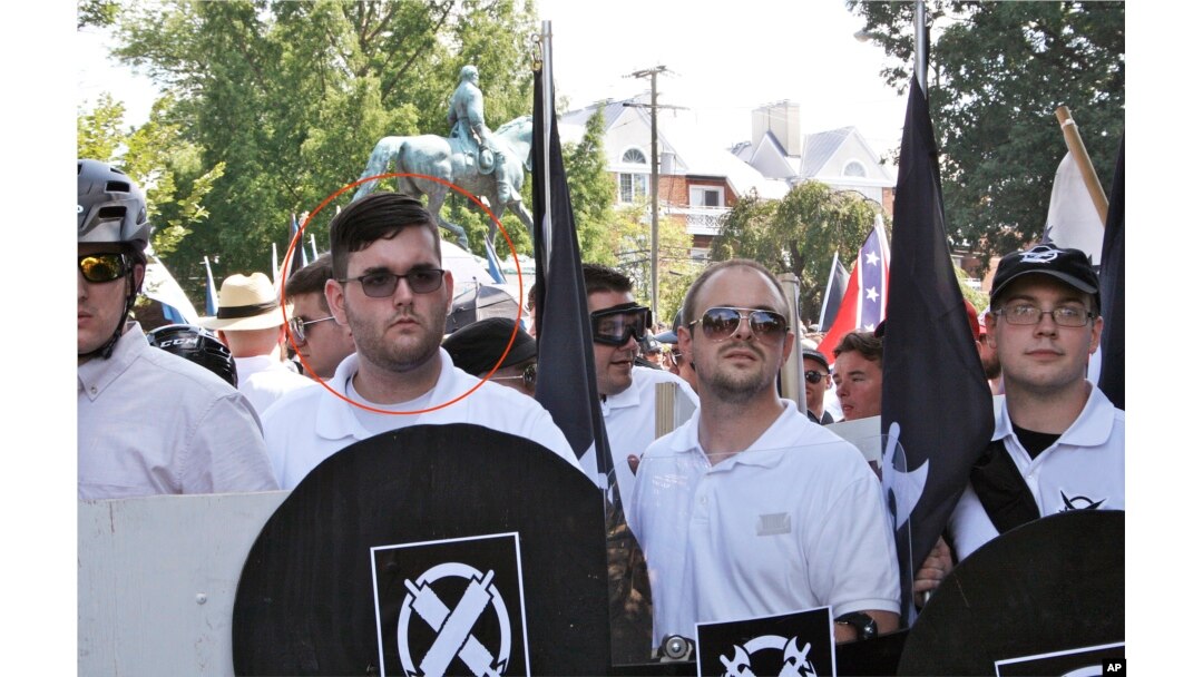 In this Saturday, Aug. 12, 2017 photo, James Alex Fields Jr., second from left, holds a black shield in Charlottesville, Va., where a white supremacist rally took place.