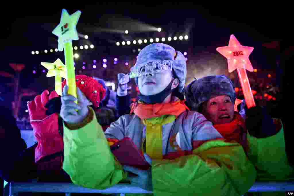 People wait for celebrating the New Year during a New Year's Eve countdown event in front of Beijing's National Stadium, known as the Bird's Nest, in Beijing, China.