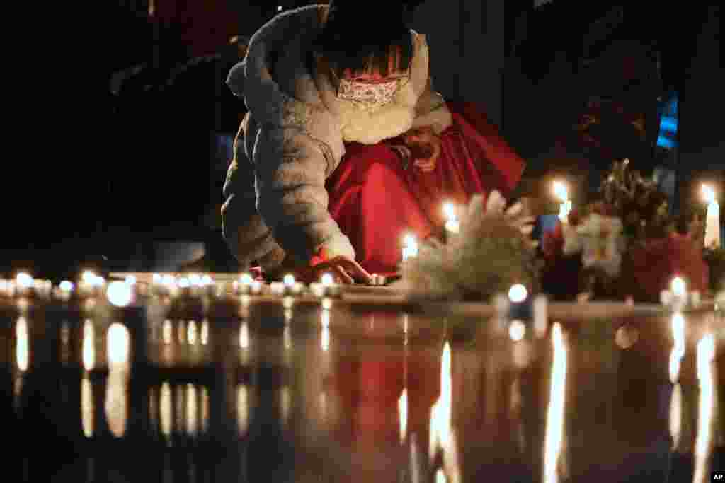A girl lights candles at the site after the "Goddess of Democracy" statue, a memorial for those killed in the 1989 Tiananmen crackdown, was removed from the Chinese University of Hong Kong.
