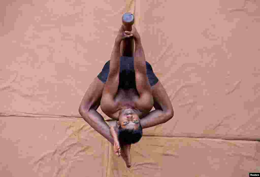 A participant practices "Mallakhamb" (traditional Indian gymnastics) during a practice session in Ahmedabad, India.