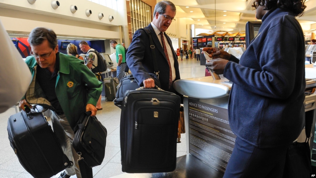 FILE - Passengers check-in their luggage at the Delta counter at Hartsfield-Jackson Atlanta International Airport, in Atlanta, Sept. 27, 2013.