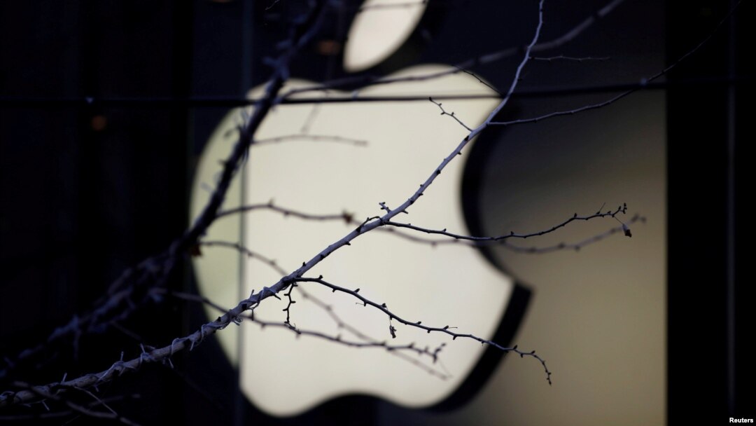 FILE - An Apple company logo is seen behind tree branches outside an Apple store in Beijing, Dec. 14, 2018. 