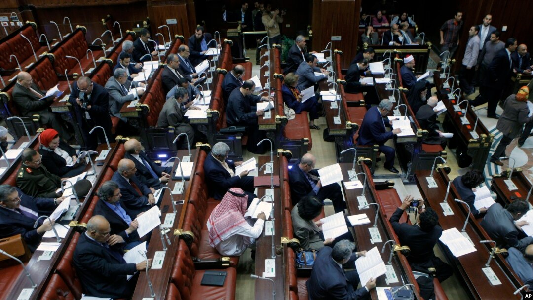 Members of Egypt's panel tasked with amending Egypt's Islamist-drafted constitution, read drafts of the constitution before they begin voting on a series of amendments, Cairo, Egypt, Saturday, Nov. 30, 2013. 