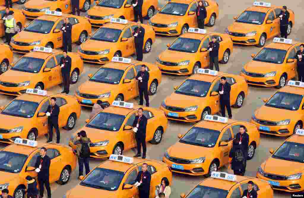 People attend an unveiling ceremony for a fleet of new methanol-fueled taxis, developed by Geely, in Xian, Shaanxi province, China. (Stringer Network)