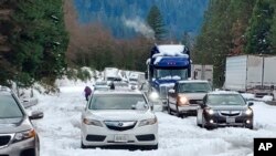 Cars and trucks are stopped in traffic on Interstate 5 near Dunsmuir, Calif., Nov. 27, 2019. Thanksgiving travel has been snarled by two powerful storms.