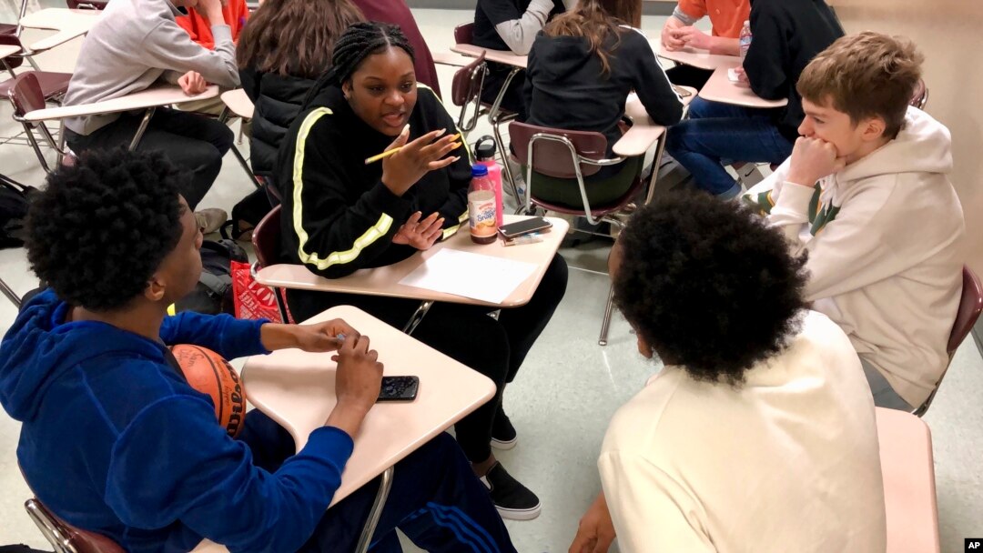 Sophomore Ramaya Wright, 15, second from left, leads a group making a list of the characteristics of an abusive relationship, during a class at Central Catholic High School in Portland, Ore., on April 15, 2019. (AP Photo/Gillian Flaccus)