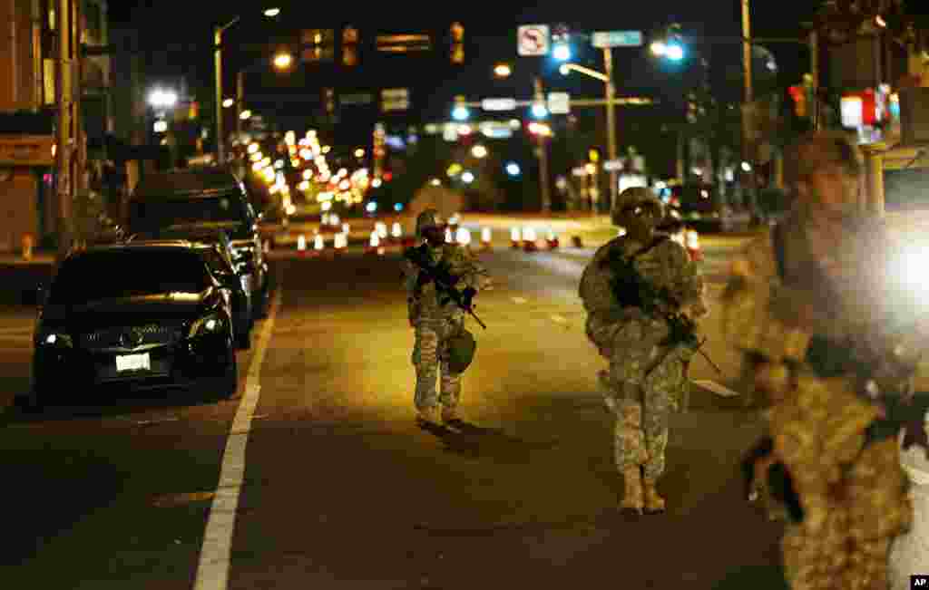 Members of the National Guard walk along North Avenue in Baltimore near where Monday's riots occurred following the funeral for Freddie Gray, after a 10 p.m. curfew went into effect Wednesday, April 29, 2015.