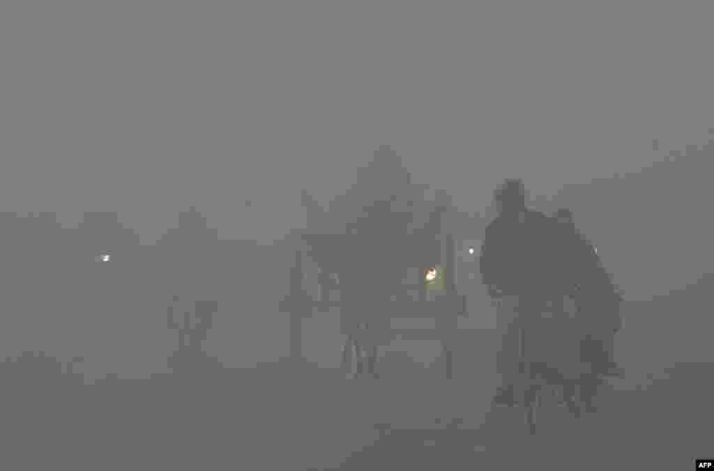 Pakistanis commute on a road amid heavy fog and smog conditions in Lahore. Smog levels spike during winter in southern Pakistan, when air quality often eclipses the World Health Organization's safe levels.