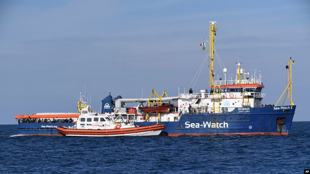 A coast guard boat approaches the German humanitarian group's rescue boat Sea Watch 3, to deliver food and blankets for the cold, off the coast of Syracuse, Italy, Jan. 27, 2019. 