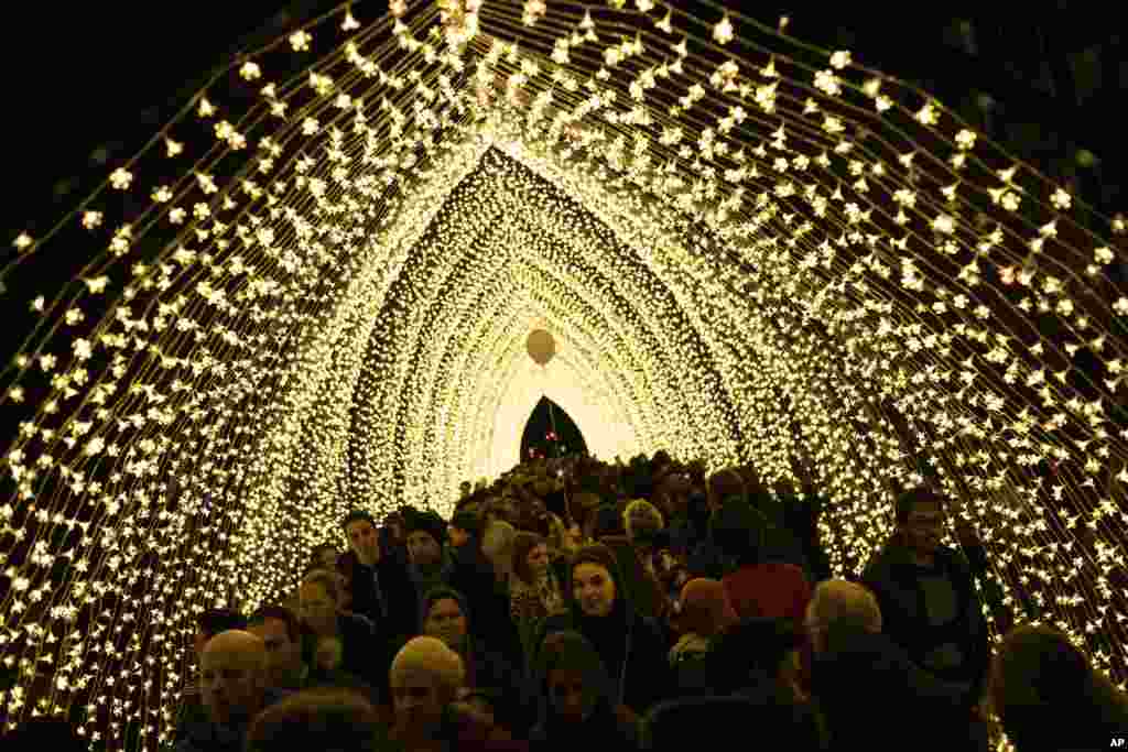 People walk along a light installation during the Bright festival in Brussels, Belgium, Feb. 17, 2019.