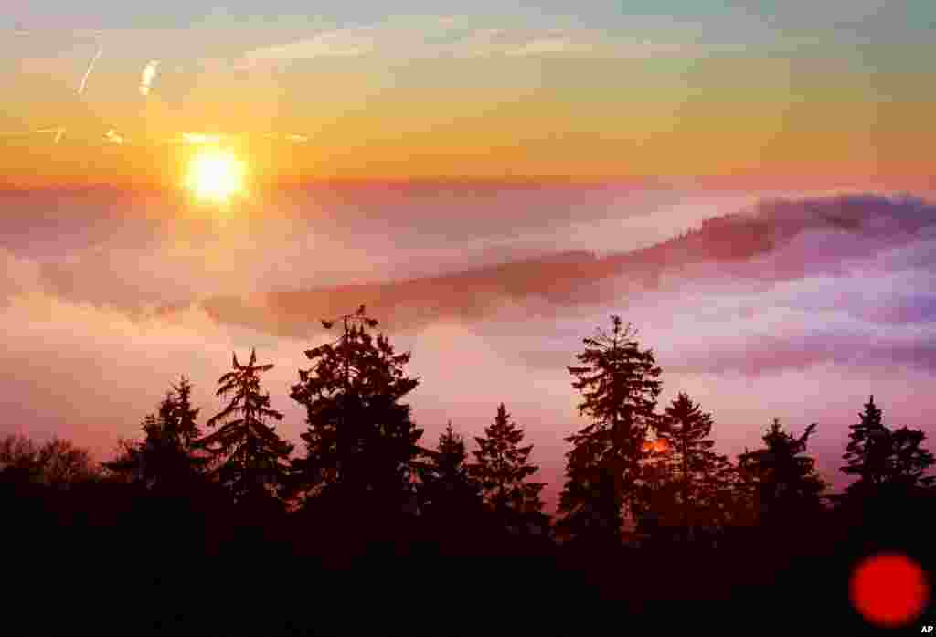 The sun rises at the horizon behind the hills of the Taunus mountains near Frankfurt, Germany.