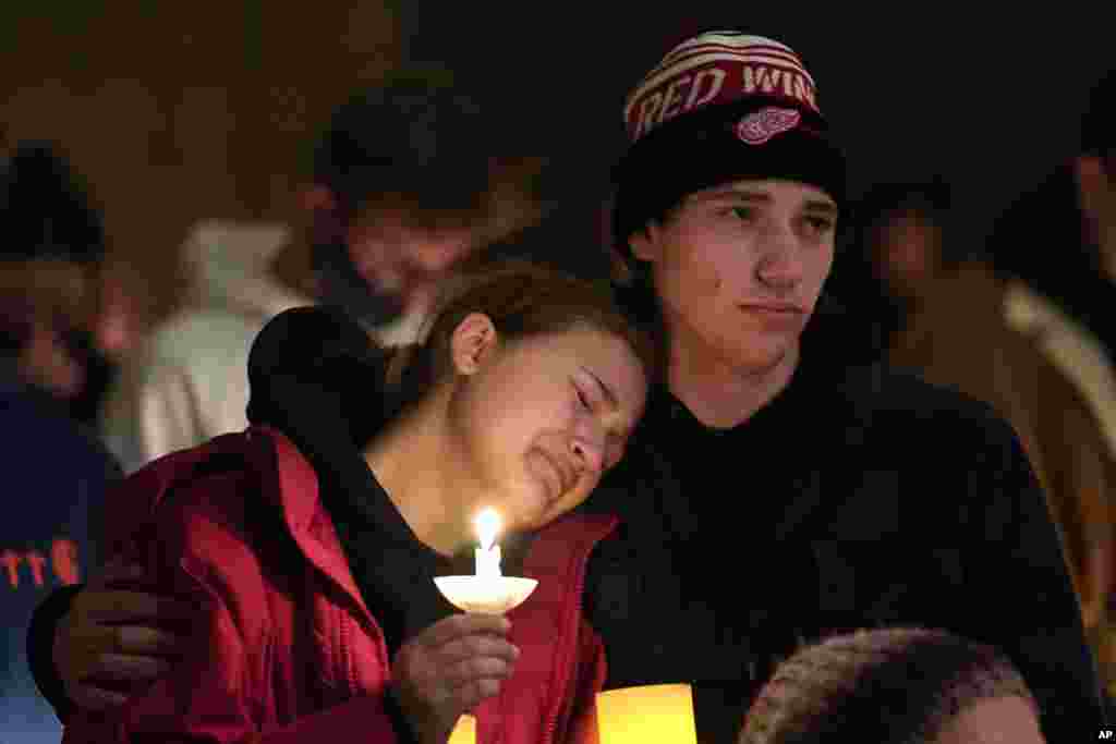 People attending a vigil embrace at LakePoint Community Church in Oxford, Michigan, Nov. 30, 2021. Authorities say a 15-year-old sophomore opened fire at Oxford High School, killing several students and wounding multiple other people, including a teacher. 