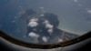 FILE - A Vietnam Air Force aircraft AN-26 flies over Con Dao island during a mission to find the missing Malaysia Airlines flight MH370, March 12, 2014.