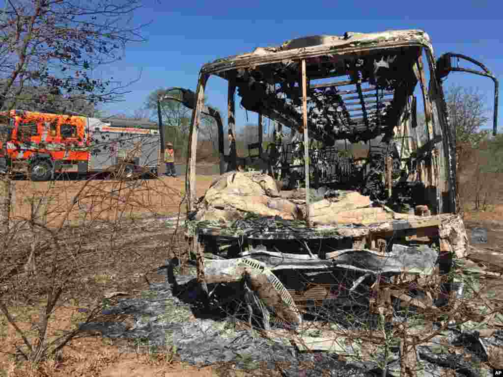 A fire engine is parked near a burnt bus after a fatal bus accident in Gwanda, south of the capital Harare, Zimbabwe, that killed more than 40 people.