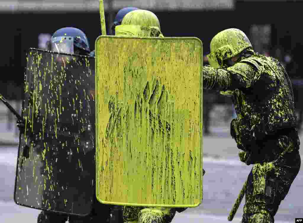 Riot police officers are covered with paint during clashes with demonstrators as part of a protest of Yellow vests (Gilets jaunes) against rising oil prices and living costs on the Champs Elysees in Paris, France, Dec. 1, 2018.