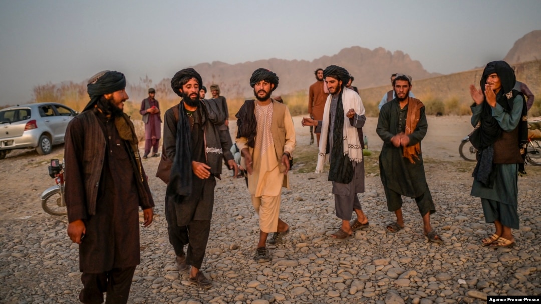 Taliban members enjoy a traditional dance on the banks of a river in Kandahar, September 23, 2021.