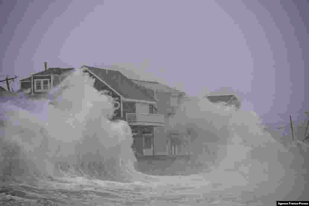 Waves crash over oceanfront homes during a nor’easter in Scituate, Massachusetts, Jan. 29, 2022.